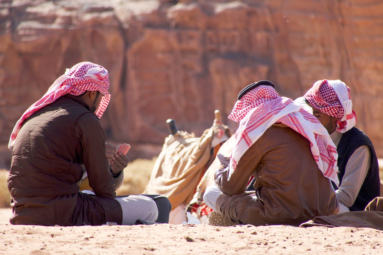 Bedouin men with camel playing cards 